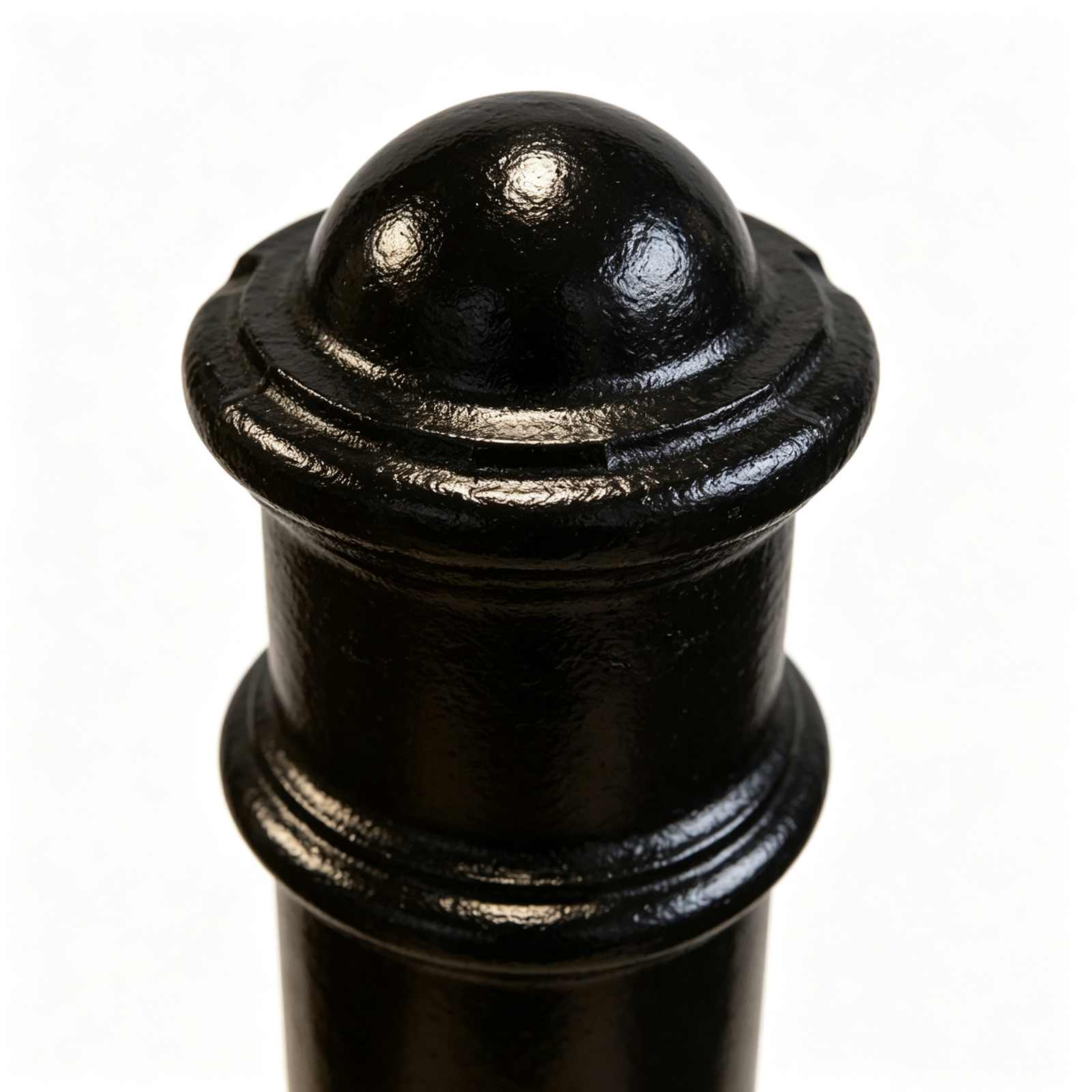Close-up detail of cast iron bollard top dome cap and decorative moulding, glossy black anti-rust coating, cast metal texture macro photo
