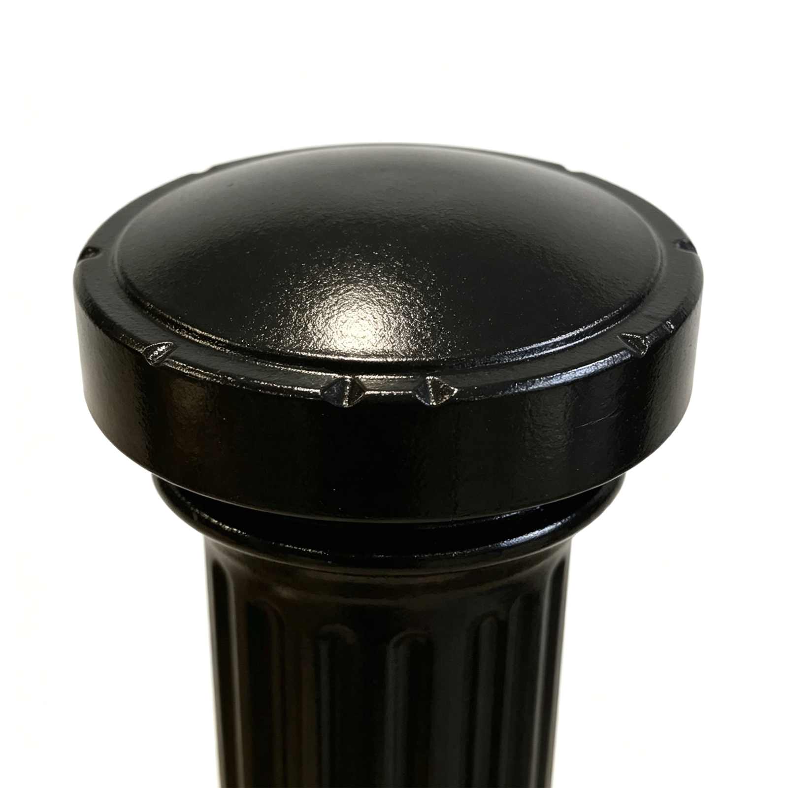 Close-up detail of fluted cast iron bollard round top cap, black painted casting texture