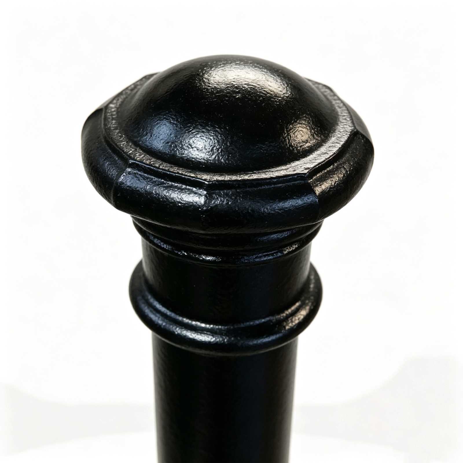 Close-up detail of cast iron bollard top cap, black painted decorative rounded head texture