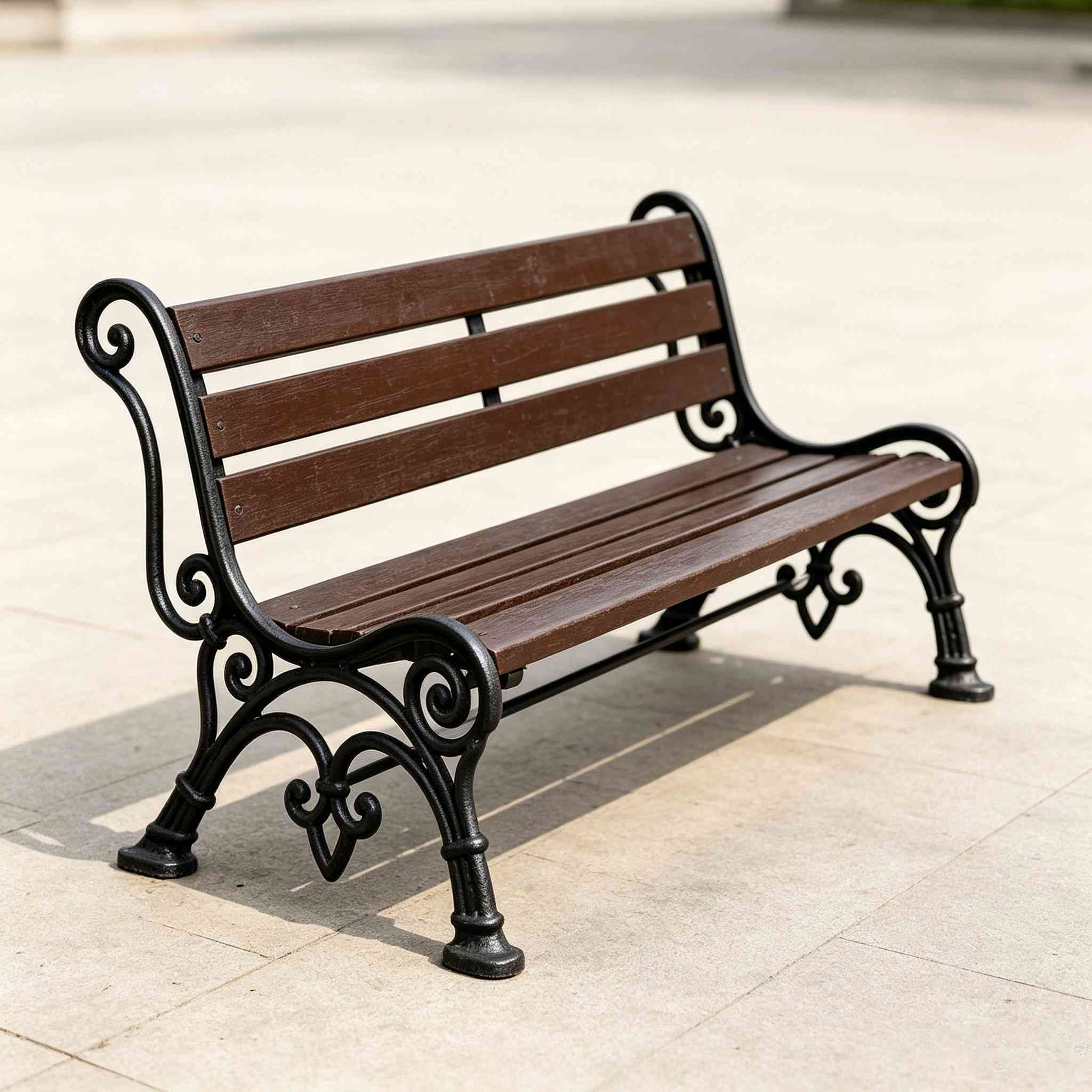 Decorative cast iron wooden park bench on pavement