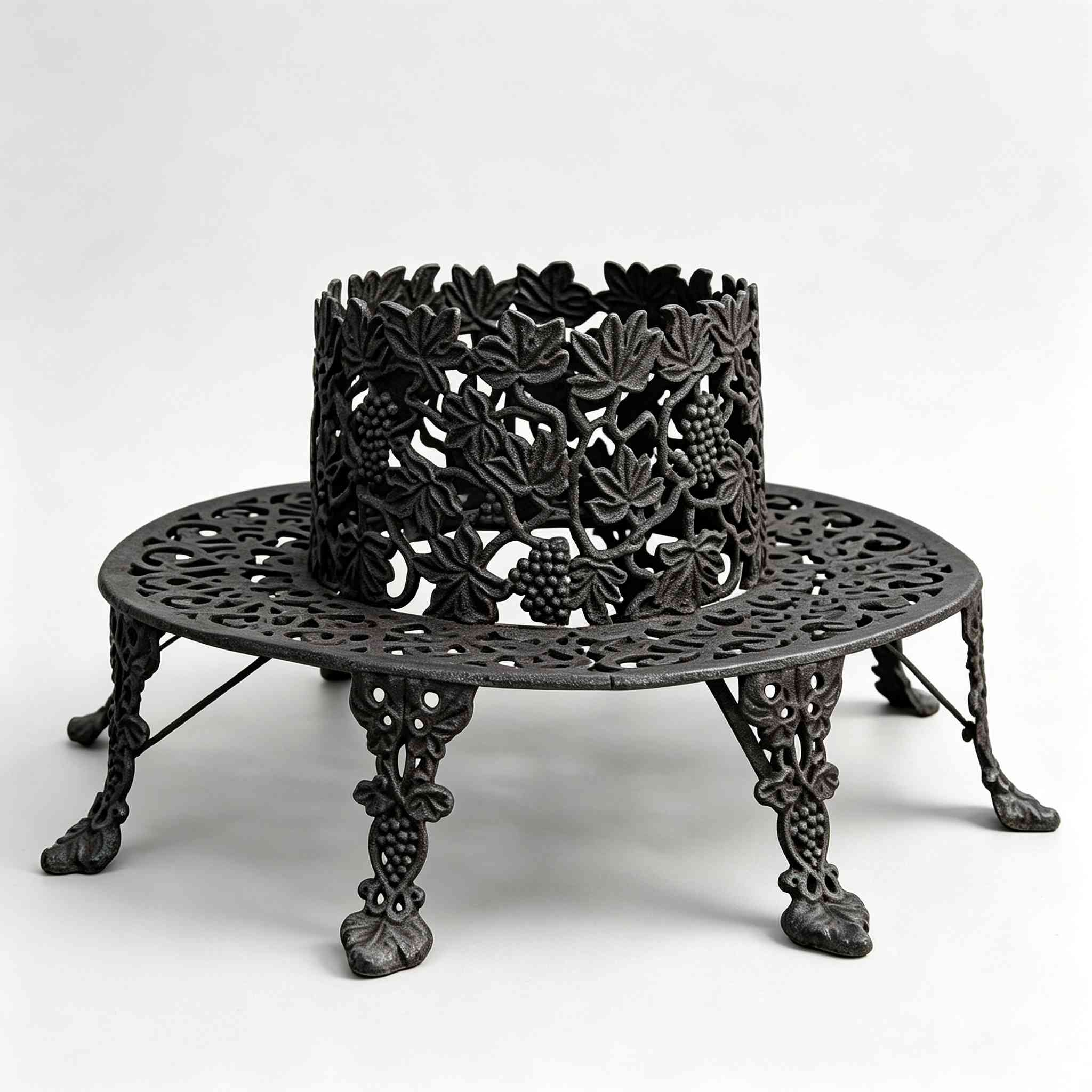 Antique black cast iron circular tree surround bench, openwork grape leaf and grape cluster carving, victorian style garden tree seat on plain white background